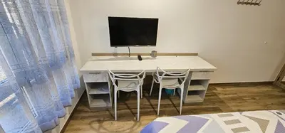 a desk with two chairs and a computer monitor on it at Vacansis Santiago Garcia Prieto y Romero Donallo Habitaciones Privadas in Santiago de Compostela