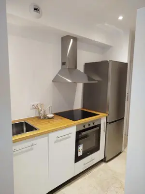 a kitchen with white cabinets and a stainless steel refrigerator at XELIÑA d in A Estrada