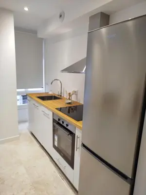 a kitchen with a stainless steel refrigerator and a sink at XELIÑA d in A Estrada
