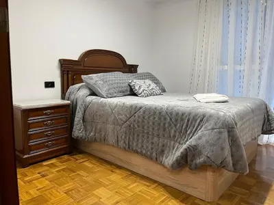 a bedroom with a bed and a dresser and a window at Piso Artur III UNIVERSIDAD in Ourense