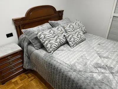 a bed with two pillows on it in a bedroom at Piso Artur III UNIVERSIDAD in Ourense