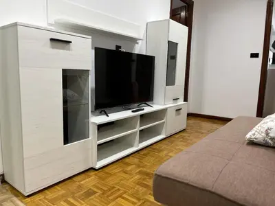 a white entertainment center with a flat screen tv at Piso Artur III UNIVERSIDAD in Ourense