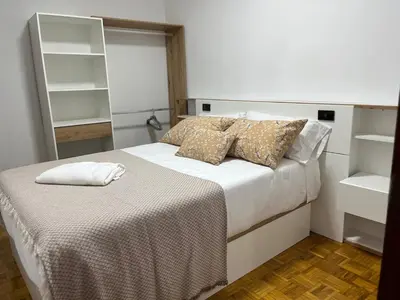 a bedroom with a bed with white sheets and pillows at Piso Artur III UNIVERSIDAD in Ourense