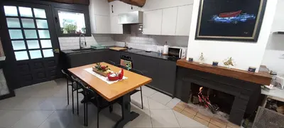 a kitchen with a table and a fireplace at Casa dos ánxeles VUT-OR-1310 in Trasmiras