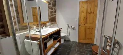 a bathroom with a sink and a toilet and a mirror at Casa dos ánxeles VUT-OR-1310 in Trasmiras