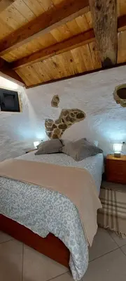 a bedroom with a large bed with a wooden ceiling at Casa dos ánxeles VUT-OR-1310 in Trasmiras