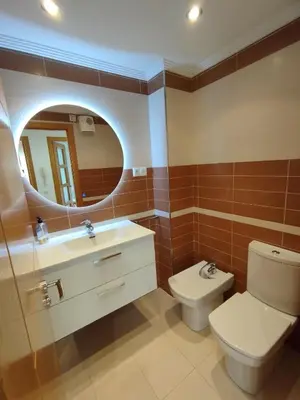 a bathroom with a toilet and a sink and a mirror at Hollyfoz Arenal in Foz