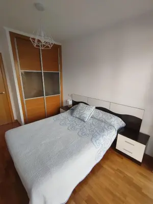 a bedroom with a bed and a chandelier at Hollyfoz Arenal in Foz