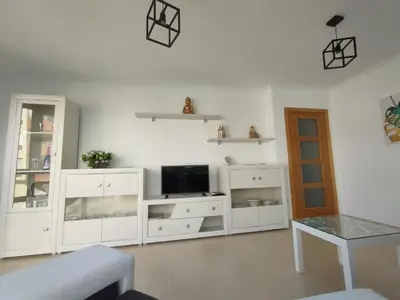a living room with white furniture and a tv at Hollyfoz Arenal in Foz