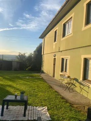 a house with a table in the grass next to it at Casa Vilamarín in Santa Eulalia