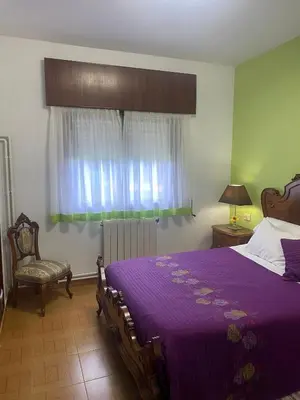 a bedroom with a purple bed and a window at Casa Vilamarín in Santa Eulalia