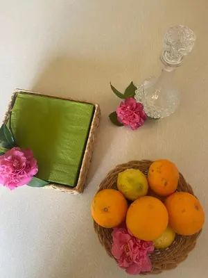 a basket of oranges and flowers next to a bottle at Casa Vilamarín in Santa Eulalia
