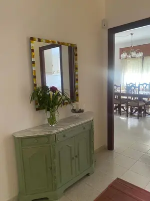a green cabinet with a mirror and a vase of flowers on it at Casa Vilamarín in Santa Eulalia