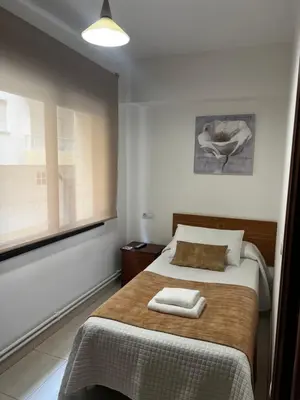a bedroom with a bed with two towels on it at Pensión Bodega de Ana in San Ciprián