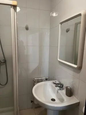 a white bathroom with a sink and a mirror at Pensión Bodega de Ana in San Ciprián