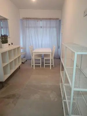 a room with a table and chairs and a table and shelves at Piso en Pontedeume enfrente hotel Eumesa in Puentedeume