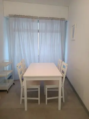 a white table and chairs in a room with a window at Piso en Pontedeume enfrente hotel Eumesa in Puentedeume