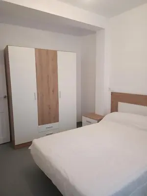 a bedroom with a white bed and a cabinet at Piso en Pontedeume enfrente hotel Eumesa in Puentedeume