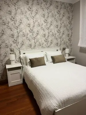 a bedroom with a large white bed with two night stands at Caldas no Camiño in Caldas de Reis