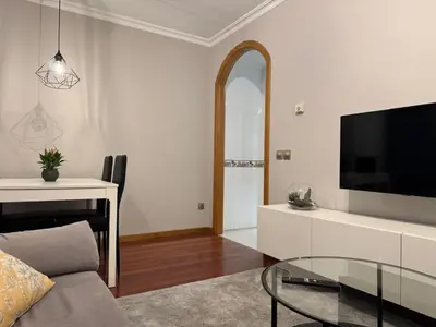 a living room with a tv and a glass table at Caldas no Camiño in Caldas de Reis