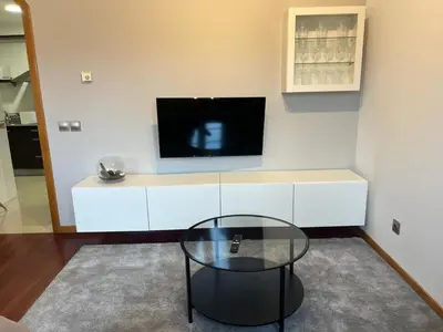 a living room with a tv and a glass table at Caldas no Camiño in Caldas de Reis