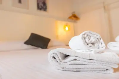 a pile of towels sitting on top of a bed at Casiña da Ribeira in Foz