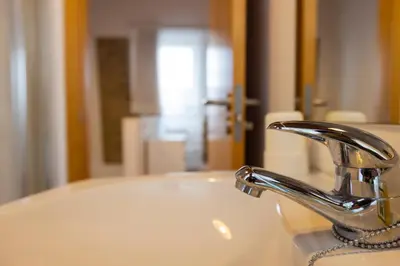 a bathroom sink with a faucet and a mirror at Casiña da Ribeira in Foz