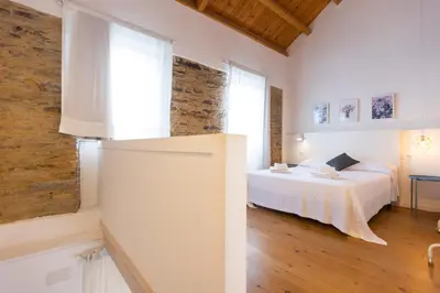 a white bedroom with a bed and a window at Casiña da Ribeira in Foz