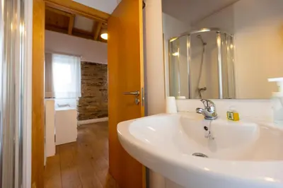 a bathroom with a white sink and a mirror at Casiña da Ribeira in Foz