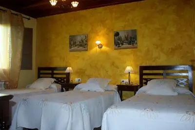 three beds in a room with yellow walls at El Capricho de Gonzalo in Cartavio