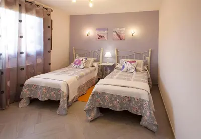 a bedroom with two beds and a window at El Capricho de Gonzalo in Cartavio