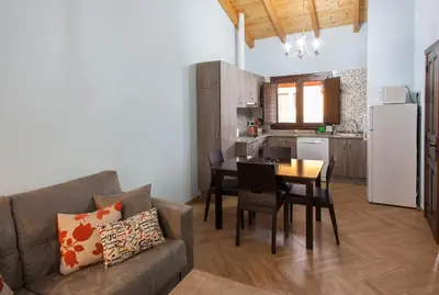 a living room with a couch and a table and a kitchen at El Capricho de Gonzalo in Cartavio