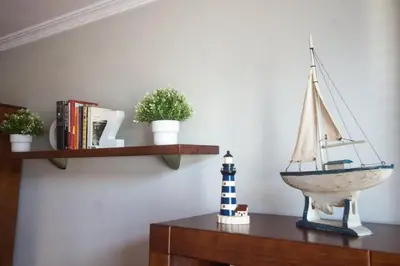 a shelf with a model boat and a toy lighthouse at EnSAN CIPRIAN Urb con Playa y Piscina in San Ciprián