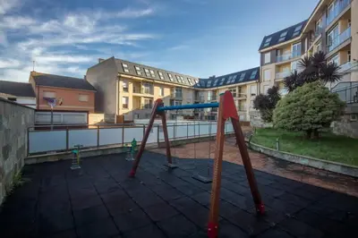 an empty playground in front of a building at EnSAN CIPRIAN Urb con Playa y Piscina in San Ciprián