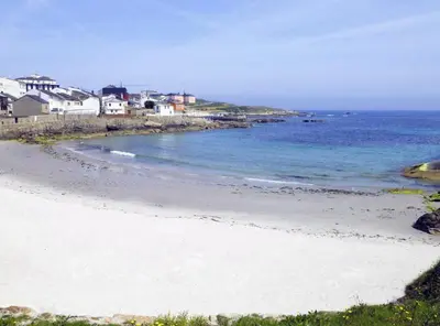 a sandy beach with houses and the ocean at EnSAN CIPRIAN Urb con Playa y Piscina in San Ciprián