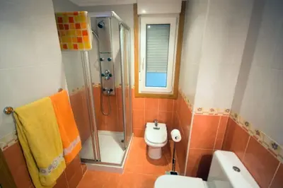 a bathroom with a shower and a toilet and a sink at EnSAN CIPRIAN Urb con Playa y Piscina in San Ciprián