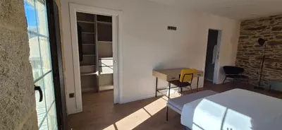 a room with a bed and a desk and a table at Casa Escuela Sanguñedo in Magdalena
