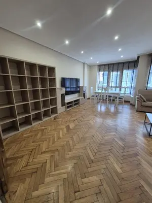 a large room with wooden floors and bookshelves at Alfonso X Lucus Confort in Lugo