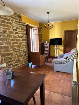 a living room with a stone wall at Penouta in Boal