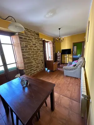a living room with a table and a brick wall at Penouta in Boal