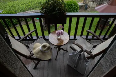 a table with two chairs and a hat on a balcony at Casal de Armán in Camporredondo