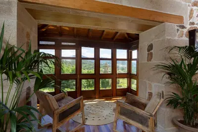 a room with two chairs and a large window at Casal de Armán in Camporredondo