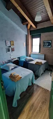 a bedroom with two beds in a room at Alberguecasaflor in Murias de Rechivaldo