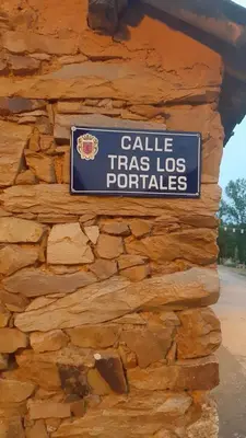 a sign on the side of a stone wall at Alberguecasaflor in Murias de Rechivaldo