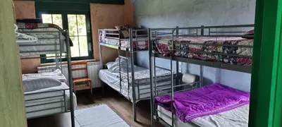 a room with three bunk beds and a window at Alberguecasaflor in Murias de Rechivaldo