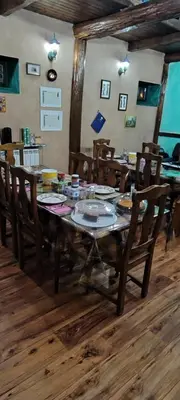 a wooden table with wooden chairs and a dining room at Alberguecasaflor in Murias de Rechivaldo