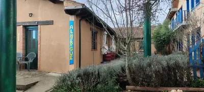 a building with a blue sign on the side of it at Alberguecasaflor in Murias de Rechivaldo