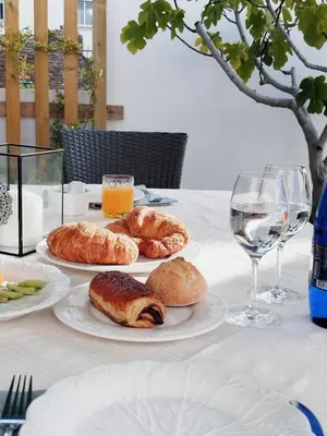 a table with plates of pastries and glasses of wine at Hotel Apartamentos Casas da Fortaleza in Lugo