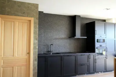 a kitchen with gray cabinets and a sink and a door at Hotel Apartamentos Casas da Fortaleza in Lugo
