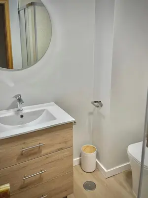 a bathroom with a sink and a toilet and a mirror at A Paradiña de Sarria in Sarria